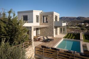eine Villa mit Swimmingpool und ein Haus in der Unterkunft Alba Lilia II in Pitsidia