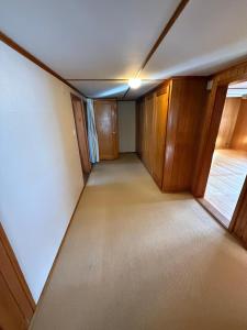 LaVida Wave Lakeside Haven am Thunersee & Alps في ليسيغن: غرفة فارغة بها دواليب خشبية ونافذة