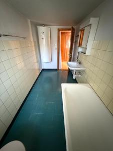 LaVida Wave Lakeside Haven am Thunersee & Alps في ليسيغن: حمام مع أرضية زرقاء ومغسلة