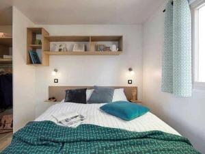 una camera da letto con un letto con una coperta verde di Camping 4 étoiles - Piscine - eeebgi a La Faute-sur-Mer Altre 73 foto