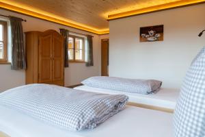 two beds in a room with two windows at Kaffeekandl Café & Pension in Glonn
