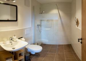 a bathroom with a shower and a toilet and a sink at Kaffeekandl Café & Pension in Glonn