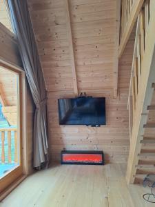 a room with a flat screen tv on a wooden wall at Grahovo Čelin Stream in Grahovo