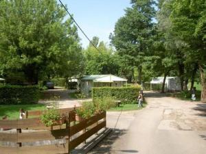 a child standing in a yard next to a fence at ZEcamping 4 familial animaux acceptés avec piscine et soirées animées in Lons-le-Saunier