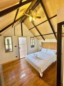 a bedroom with a bed and a ceiling fan at Phayam Paradise Resort in Ko Phayam