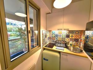 eine kleine Küche mit Spüle und Fenster in der Unterkunft Studio grande terrasse à 5 min de la mer in Nizza