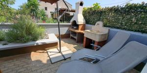 a patio with two chairs and an umbrella at Federica A2+1 in Veli Lošinj +5 photos