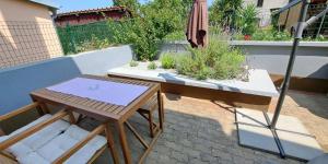 a patio with a table and an umbrella at Federica A2+1 in Veli Lošinj