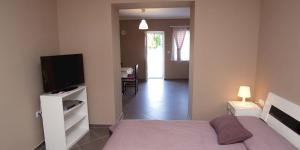a bedroom with a bed and a flat screen tv at Federica A2+1 in Veli Lošinj