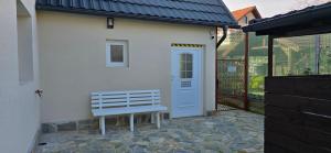 a white bench sitting in front of a house at Vila Trifoi Apartamente in Breaza de Jos