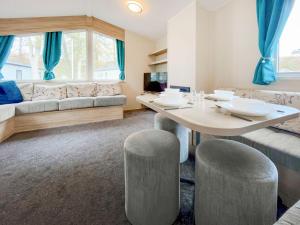 a living room with a table and a couch at Eskside Lodge in Edzell