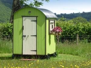 TregaronにあるCwt Cwtshlydの芝生にドアがある緑の屋外トイレ +3枚の写真