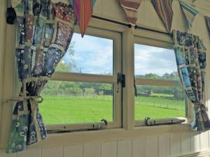 TregaronにあるCwt Cwtshlydの野原が見えるカーテンのかかった窓が2つ