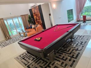 5 Bedroom Villa With Private Pool By Perkasa في كوالالمبور: طاولة بلياردو في منتصف غرفة المعيشة