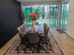 5 Bedroom Villa With Private Pool By Perkasa في كوالالمبور: غرفة طعام مع طاولة وكراسي زجاجية