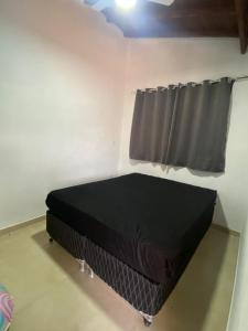 een bed in een kamer met een raam bij Recanto do entardecer in Socorro