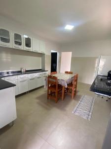 een keuken met een tafel en stoelen in een kamer bij Recanto do entardecer in Socorro