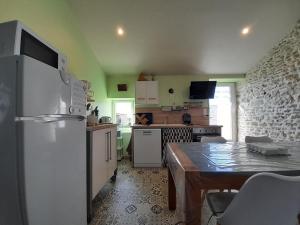 a kitchen with a white refrigerator and a table at La bergerie in Coussay