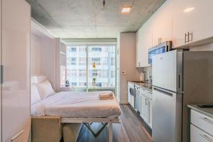a small kitchen with a bed and a refrigerator at Panoramic Studio-1BR-3BR, Pool, Gym, Parking, Patio, BBQ in Phoenix