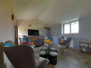 a living room with couches and chairs and a tv at La bergerie in Coussay