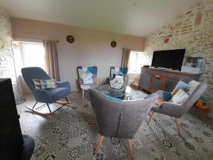 a living room with chairs and a tv at La bergerie in Coussay +17 photos