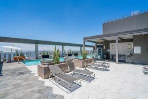 a patio with lounge chairs and a pool on a building at Panoramic Studio-1BR-3BR, Pool, Gym, Parking, Patio, BBQ in Phoenix