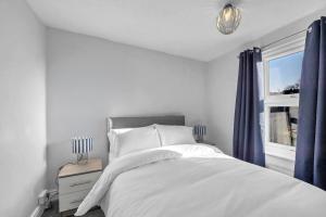 a bedroom with a white bed and a window at 17 OutRisbygate St - 3 bedroom house that sleeps 6 with one private parking space in Bury Saint Edmunds