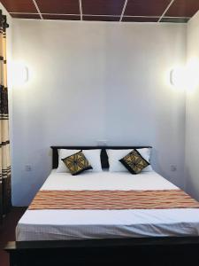 a bed with two pillows on it in a room at Shereen Sigiri Homertay in Dambulla