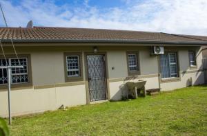 a small house with a door and a yard at Mbuso Guest House in Richards Bay