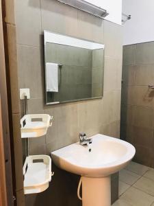 a bathroom with a sink and a mirror and a toilet at Shereen Sigiri Homertay in Dambulla