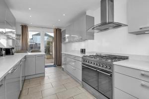 a kitchen with stainless steel appliances and white counters at 17 OutRisbygate St - 3 bedroom house that sleeps 6 with one private parking space in Bury Saint Edmunds