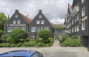 a blue car parked in front of a building at Coffee Fellows Hotel Puchheim in Puchheim