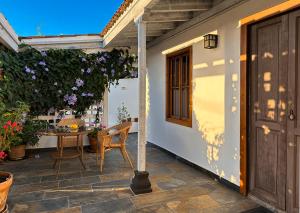 Un patio con una mesa y una ventana y flores. en Casa Los Morros, en Tazacorte