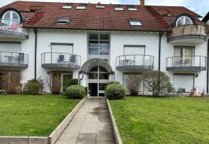 a large white house with balconies and a yard at FeWo Hess in Rust
