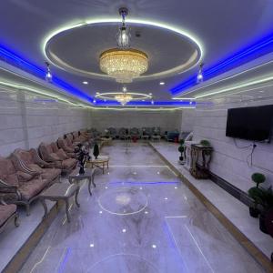 Una sala con sofás y un televisor y un escenario. en فندق التوحيد بارك 1 توصيل مجاني للحرم, en Al ‘Azīzīyah