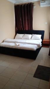 a black bed with white pillows in a room at RegisVille Hotel in Magboro
