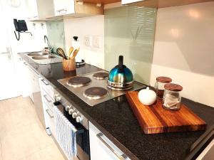 a kitchen with a stove and a wooden cutting board at 404 Horizon Bay in Bloubergstrand