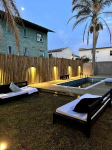 two beds sitting on the grass next to a swimming pool at Pedre Loft in La Pedrera +20 photos