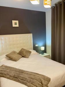 a bedroom with a white bed with two pillows on it at Oasis Rural in Ucero