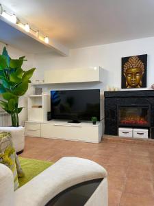 a living room with a large television and a fireplace at Oasis Rural in Ucero