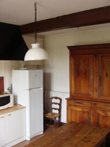 a kitchen with a white refrigerator and a wooden table at La maison du régisseur in Chauvigny