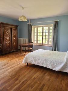 a bedroom with a bed and a table and a window at La maison du régisseur in Chauvigny