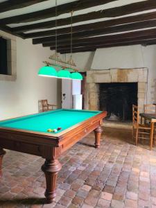 a pool table in a room with a fireplace at La maison du régisseur in Chauvigny