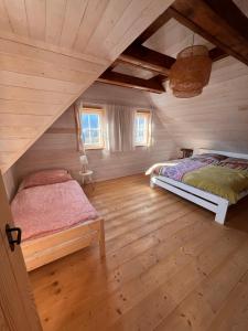 a bedroom with two beds in a attic at Roubenka in Terchová