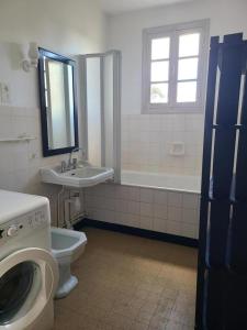 a bathroom with a toilet and a sink and a washing machine at La maison du régisseur in Chauvigny +14 photos