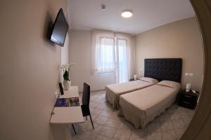 a hotel room with two beds and a mirror at Hotel Viña del Mar Pineta in Lido di Jesolo