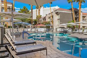 una piscina con sedie e ombrelloni in un hotel di Desert Rose Resort a Las Vegas