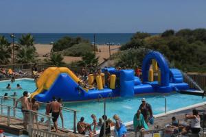 a group of people in a pool at a water park at ZEcamping 4 étoiles chiens acceptés piscine chauffée et toboggans in Portiragnes