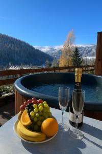 a plate of fruit on a table with a bottle of wine at Ośrodek Wypoczynkowy Pod Dębem in Wójtowice