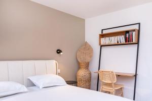 ヴィルールバンヌにあるLa Maison Bretzelのベッドと机と椅子のある寝室